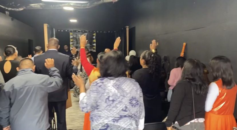 LPH congregation in worship with hands raised
